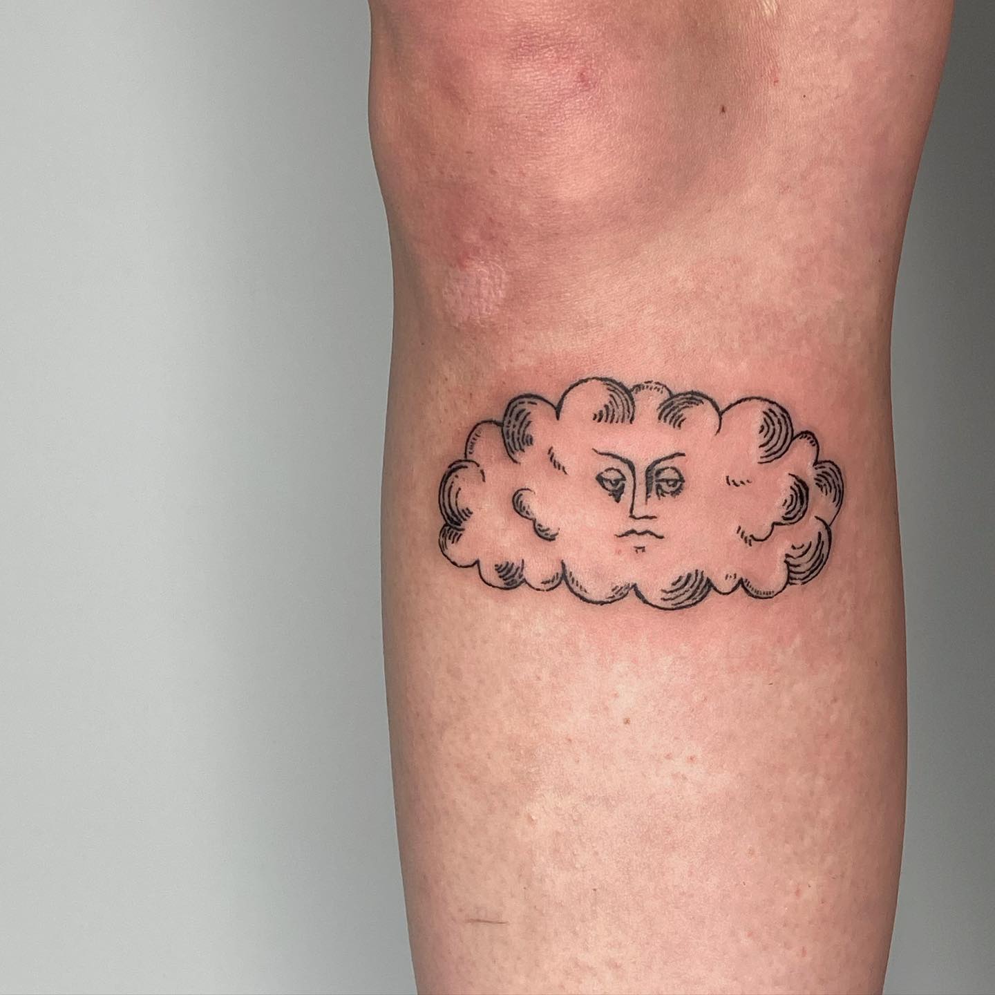 Tatuaje de nube en la rodilla.