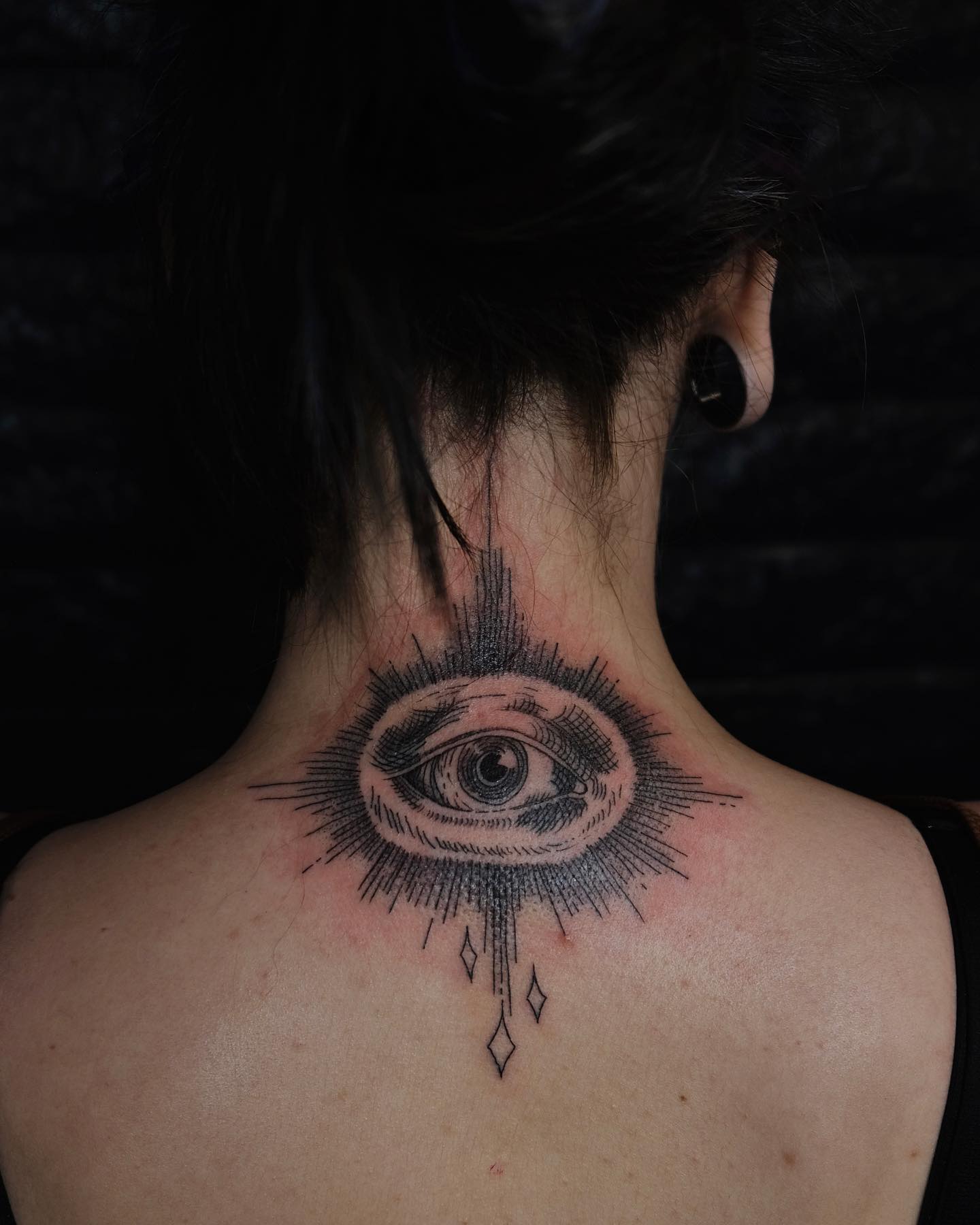 Tatuaje del ojo que todo lo ve en tinta negra en la espalda