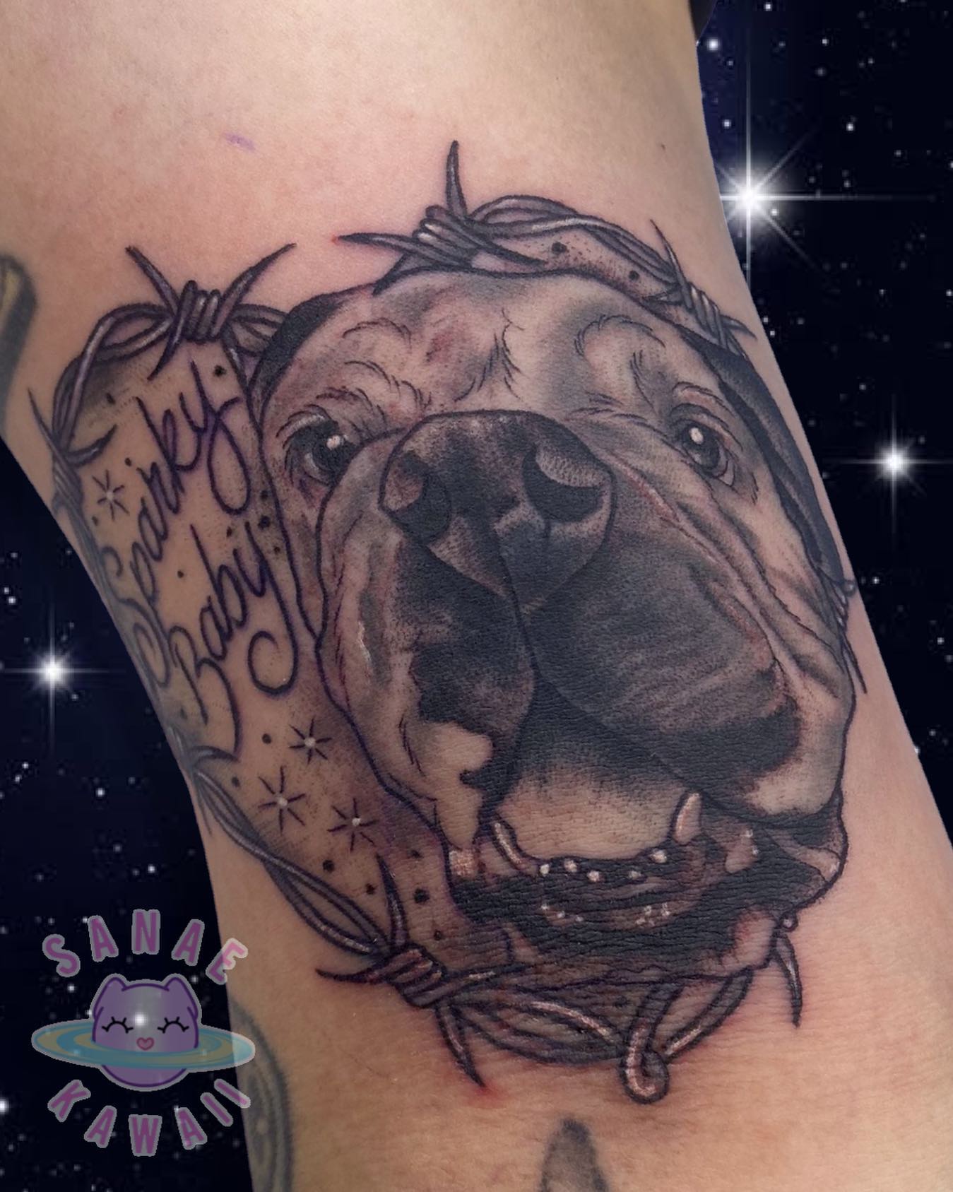 Alambre de púas con forma de corazón y tatuaje de perro.