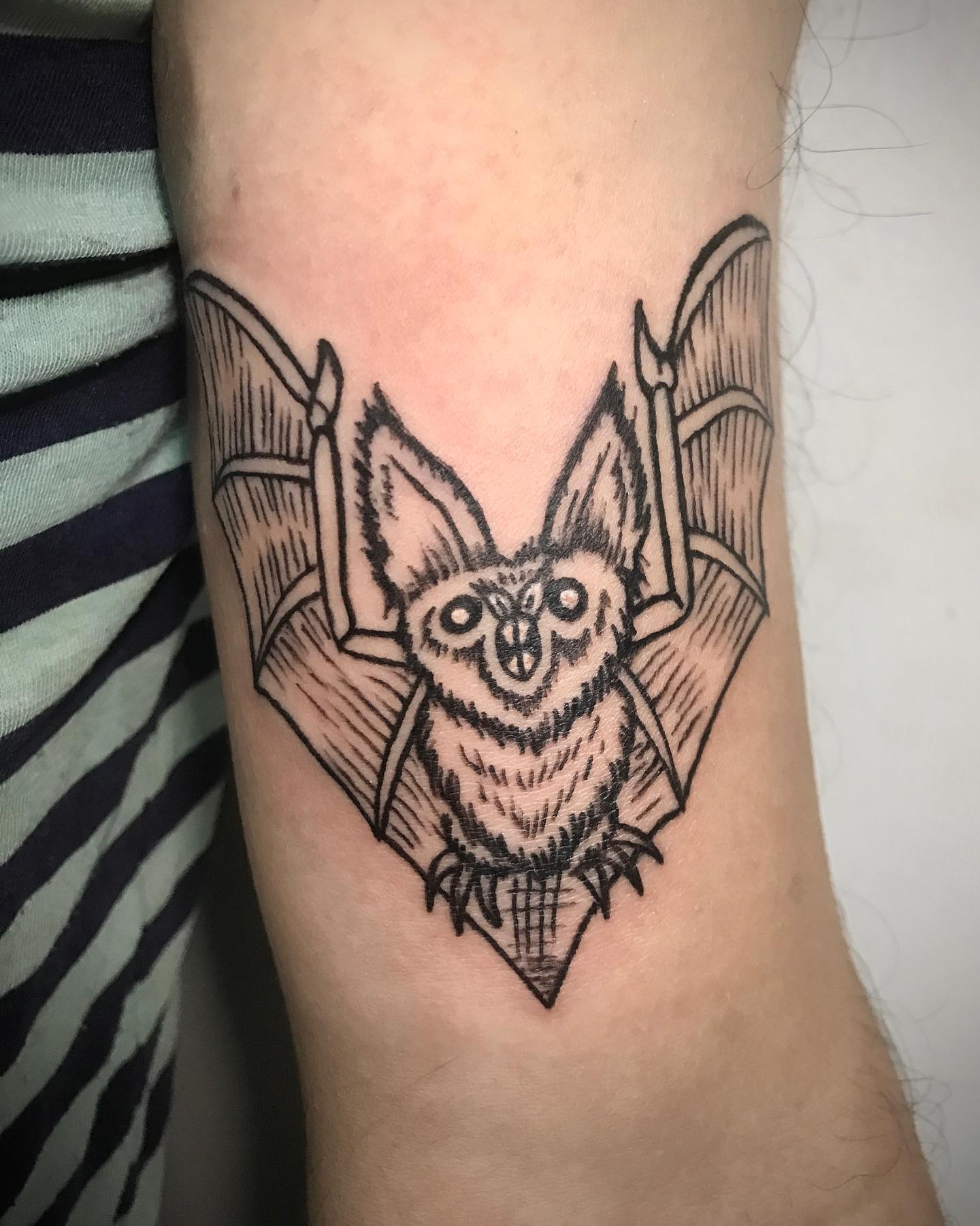 Diseño de tatuaje de murciélago con tinta negra.