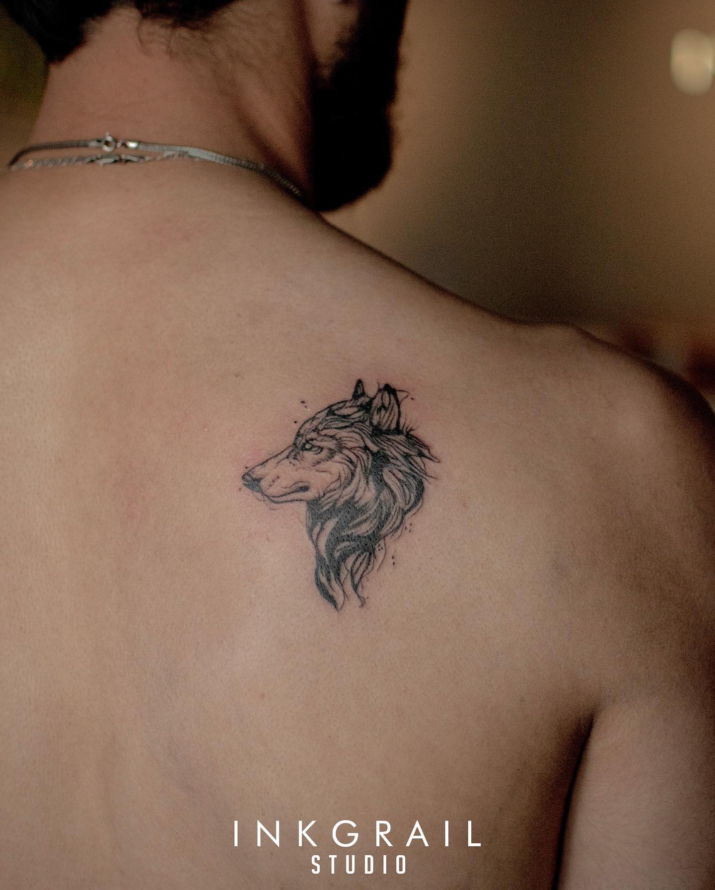 Pequeño tatuaje de lobo en la espalda.