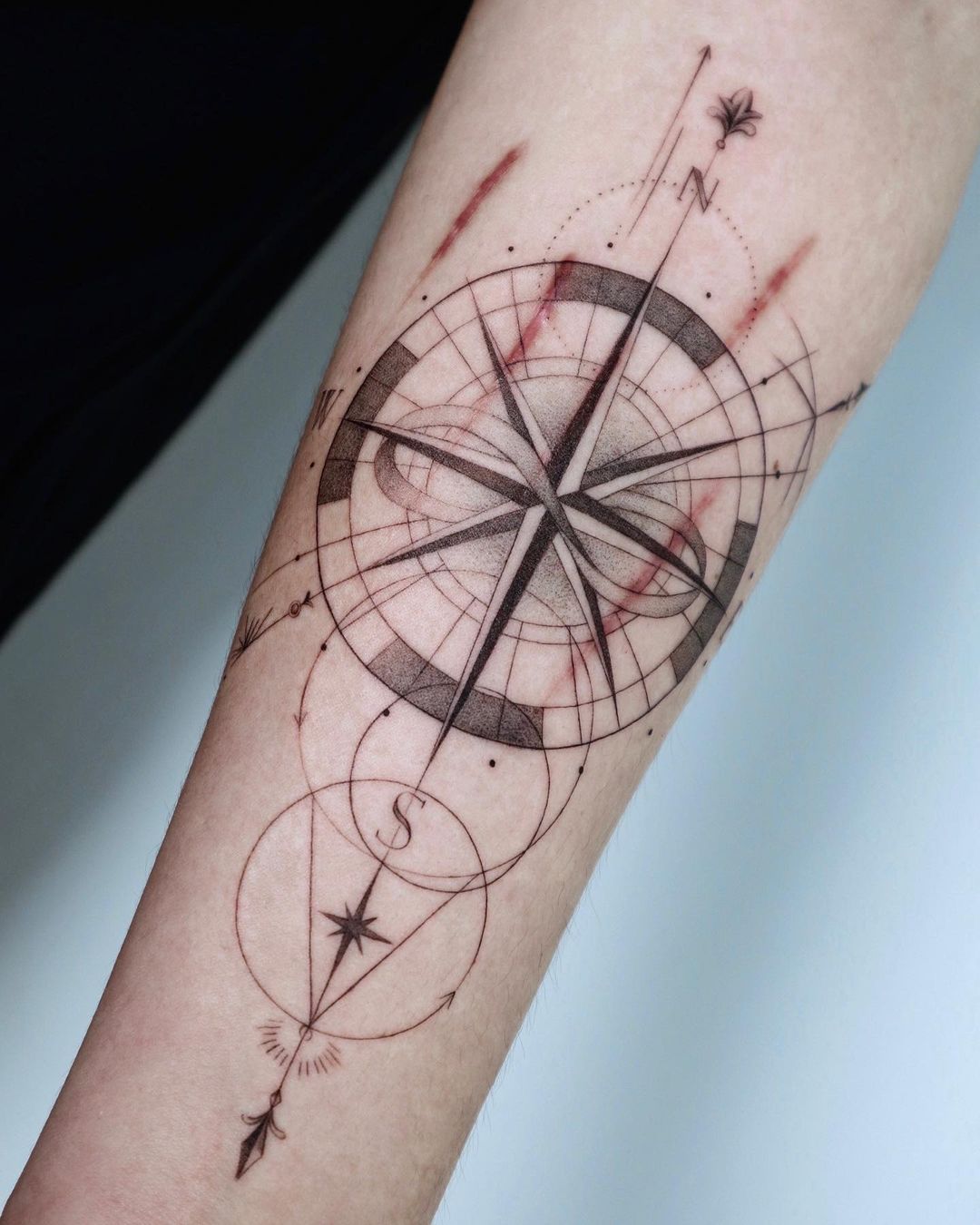 Tatuaje de compás geométrico.
