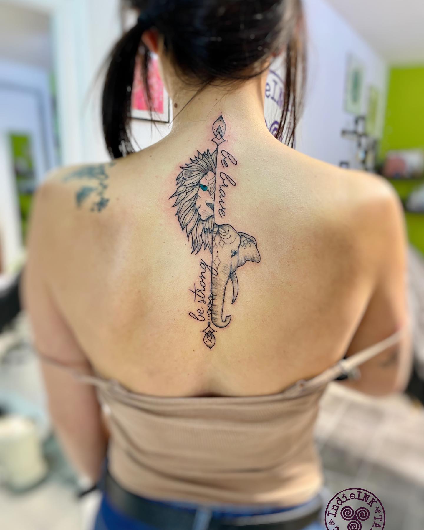 Tatuaje de Elefante y León con Líneas en la Espalda.