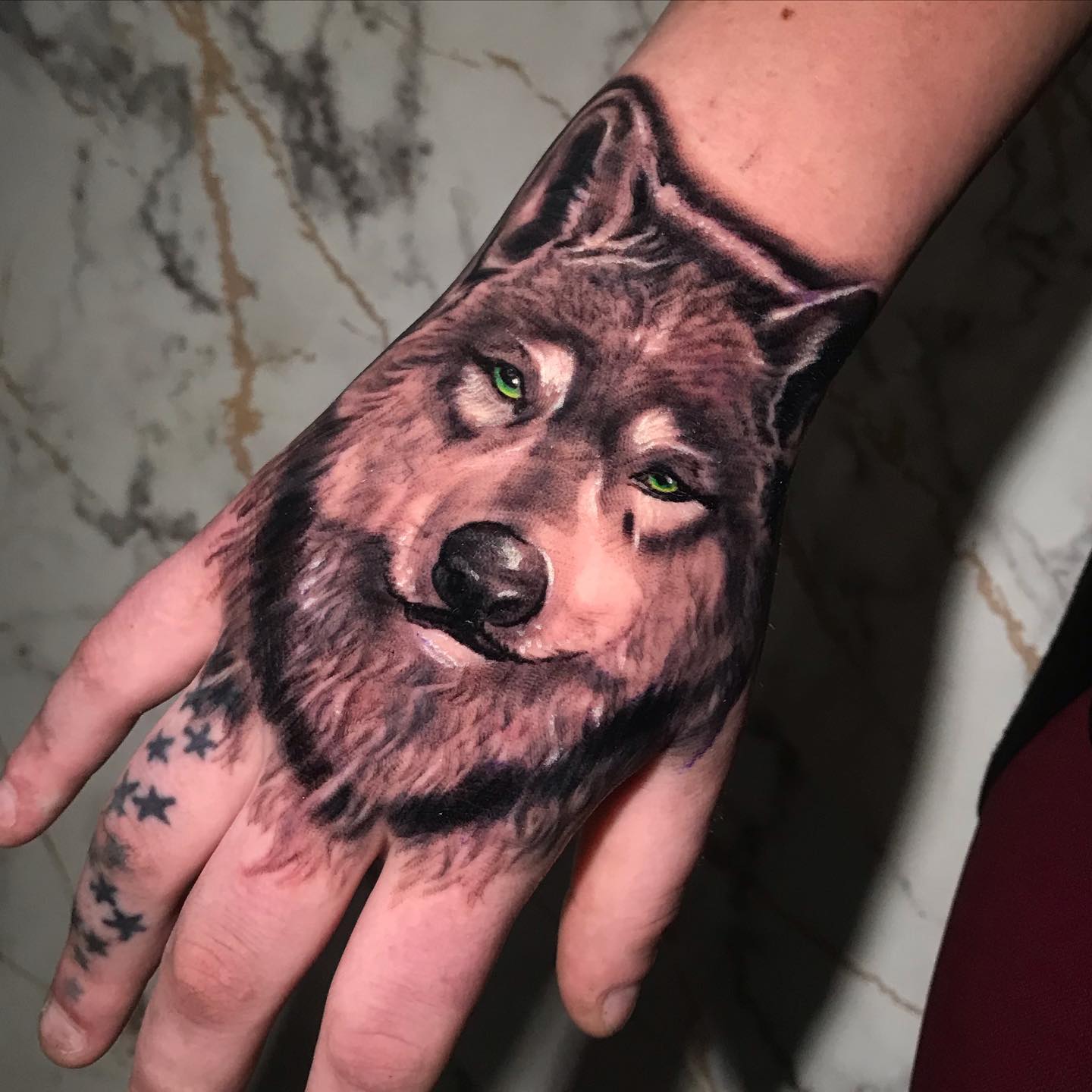Tatuaje de lobo en la mano.