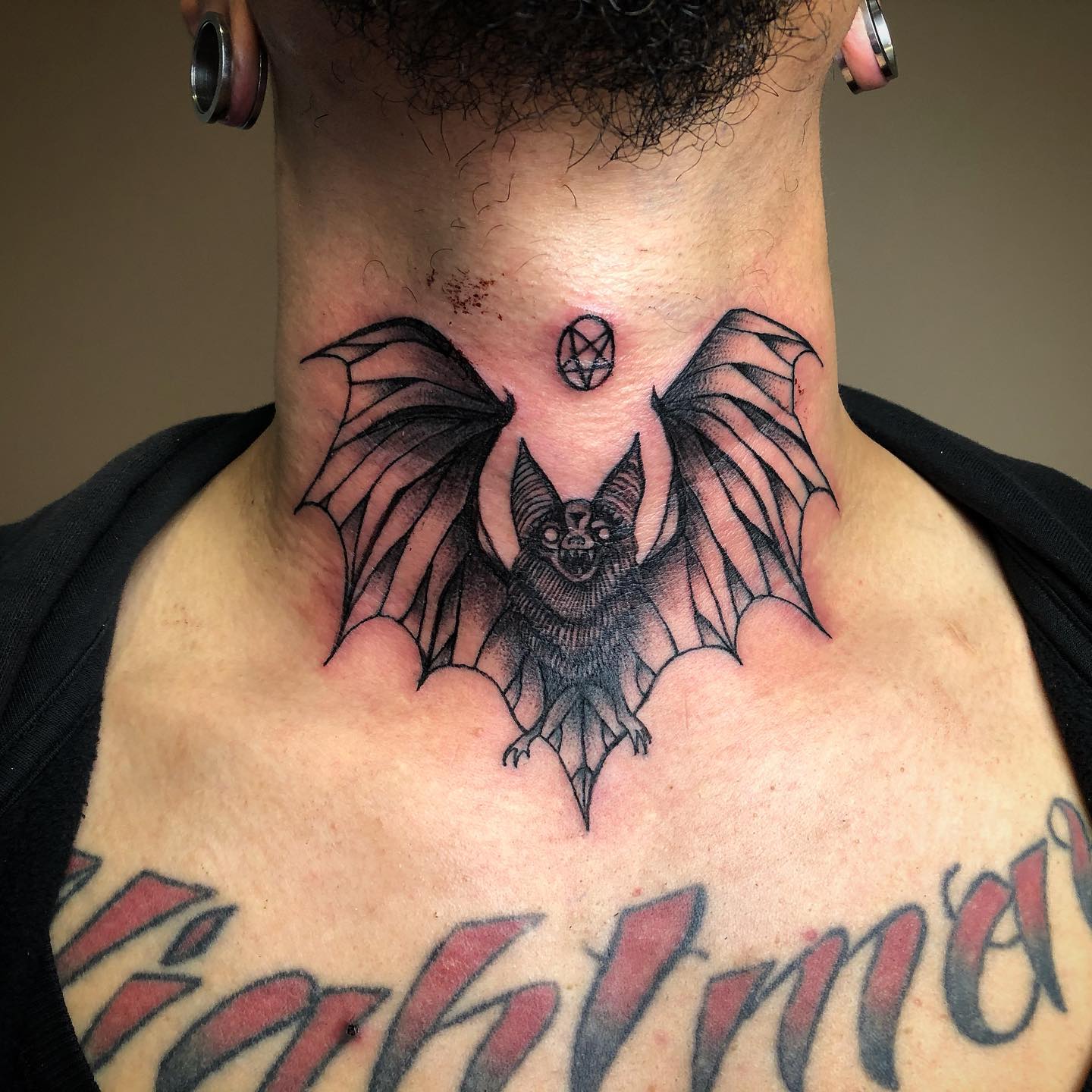 Tatuaje de murciélago en el cuello