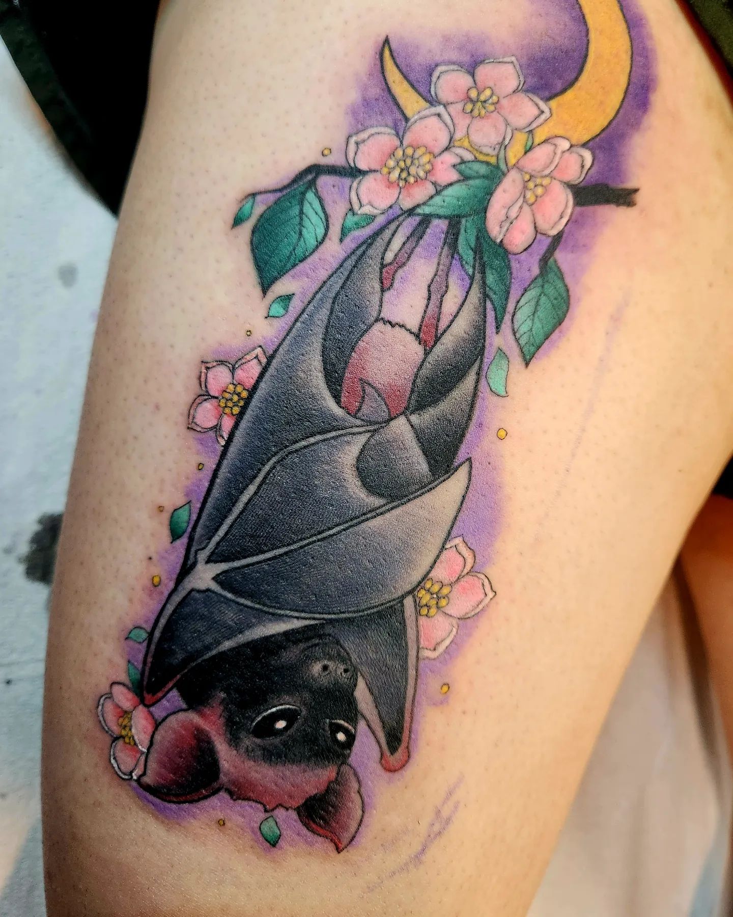 Tatuaje vibrante de un murciélago en el muslo