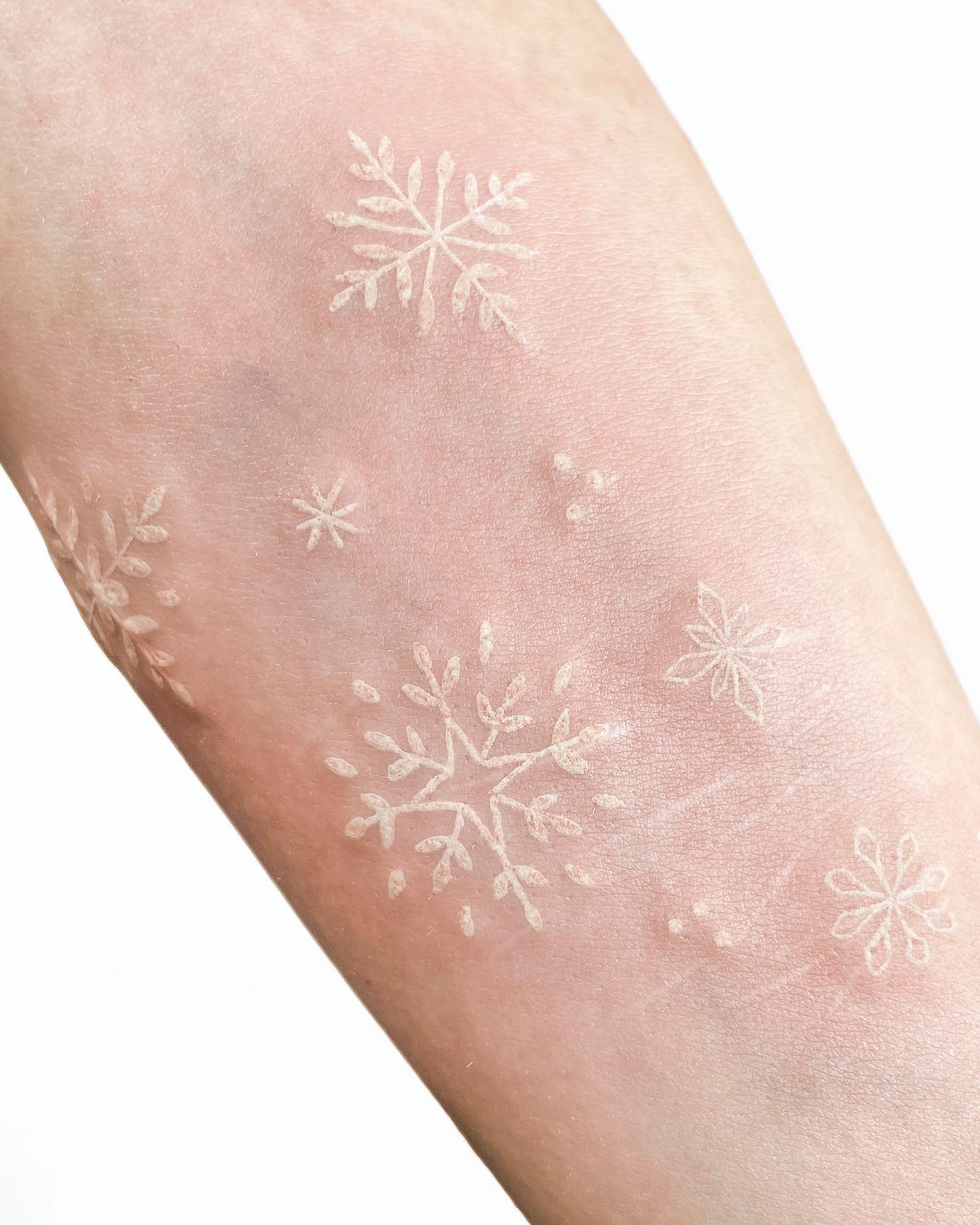 Tatuaje de copo de nieve con tinta blanca