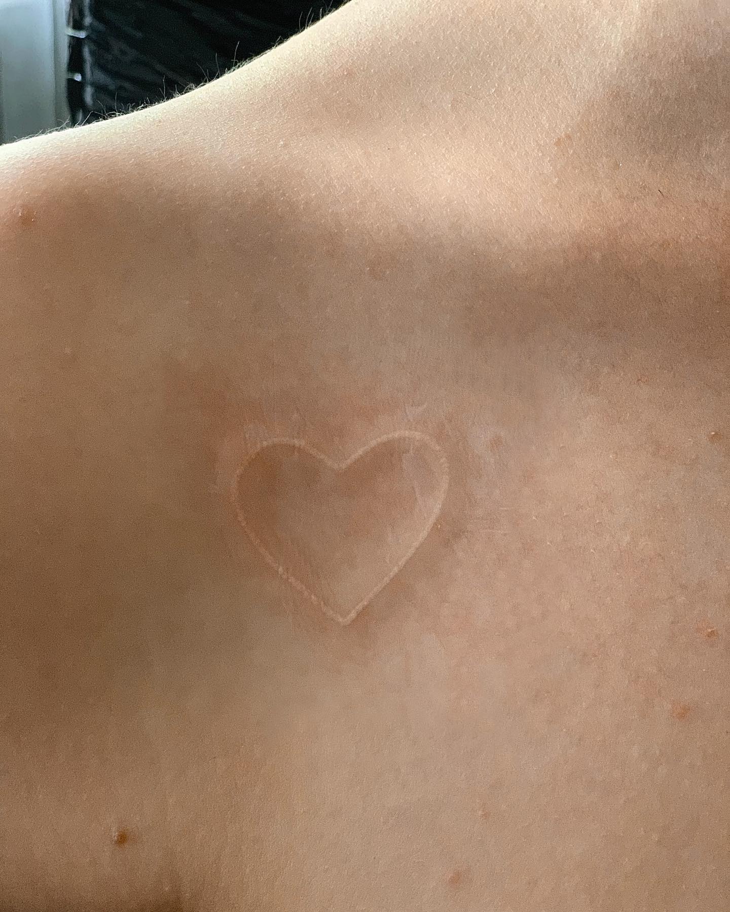 Tatuaje de corazón con tinta blanca