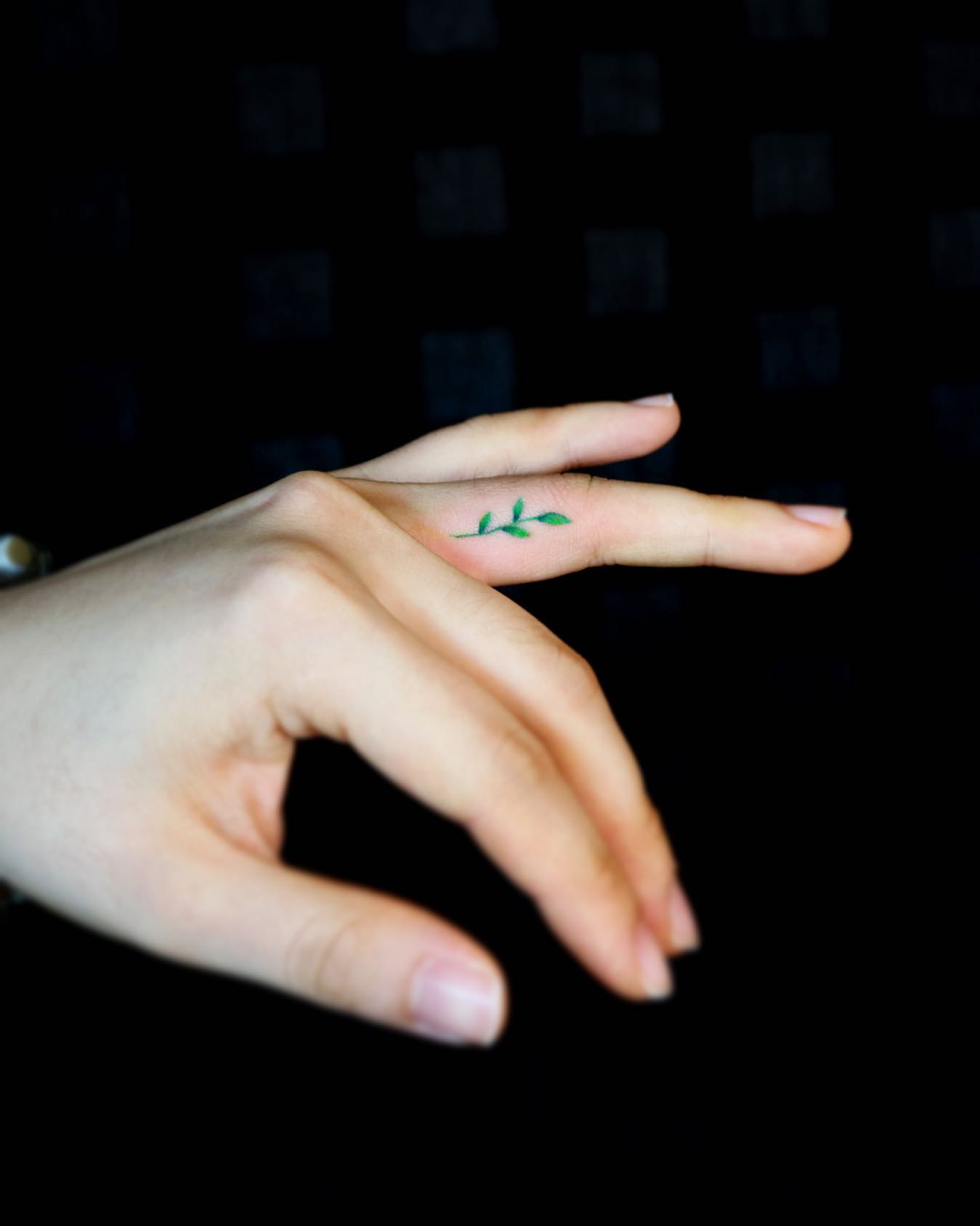 Tatuaje de hoja colorida en el dedo