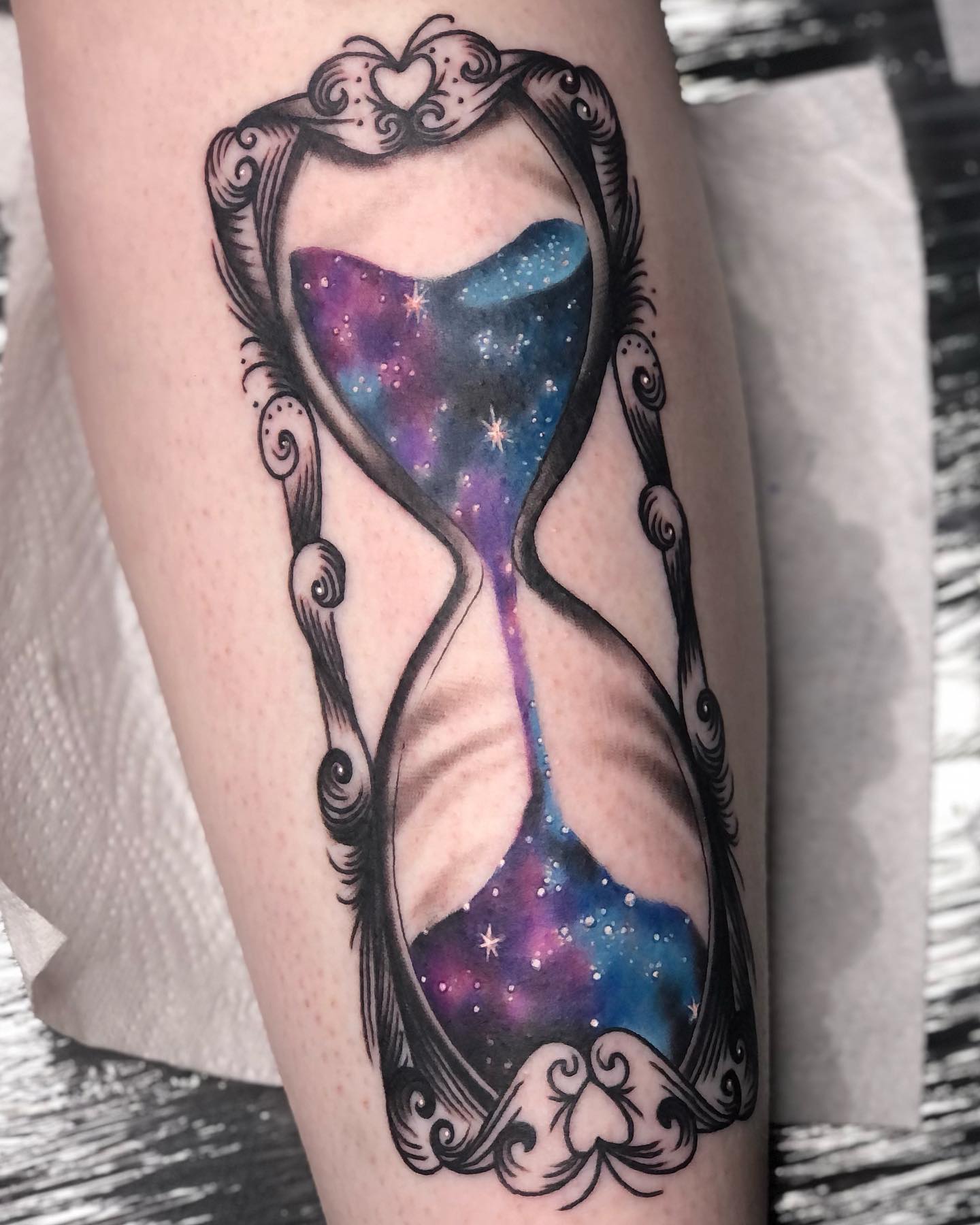 Tatuaje de reloj de arena mágico púrpura.