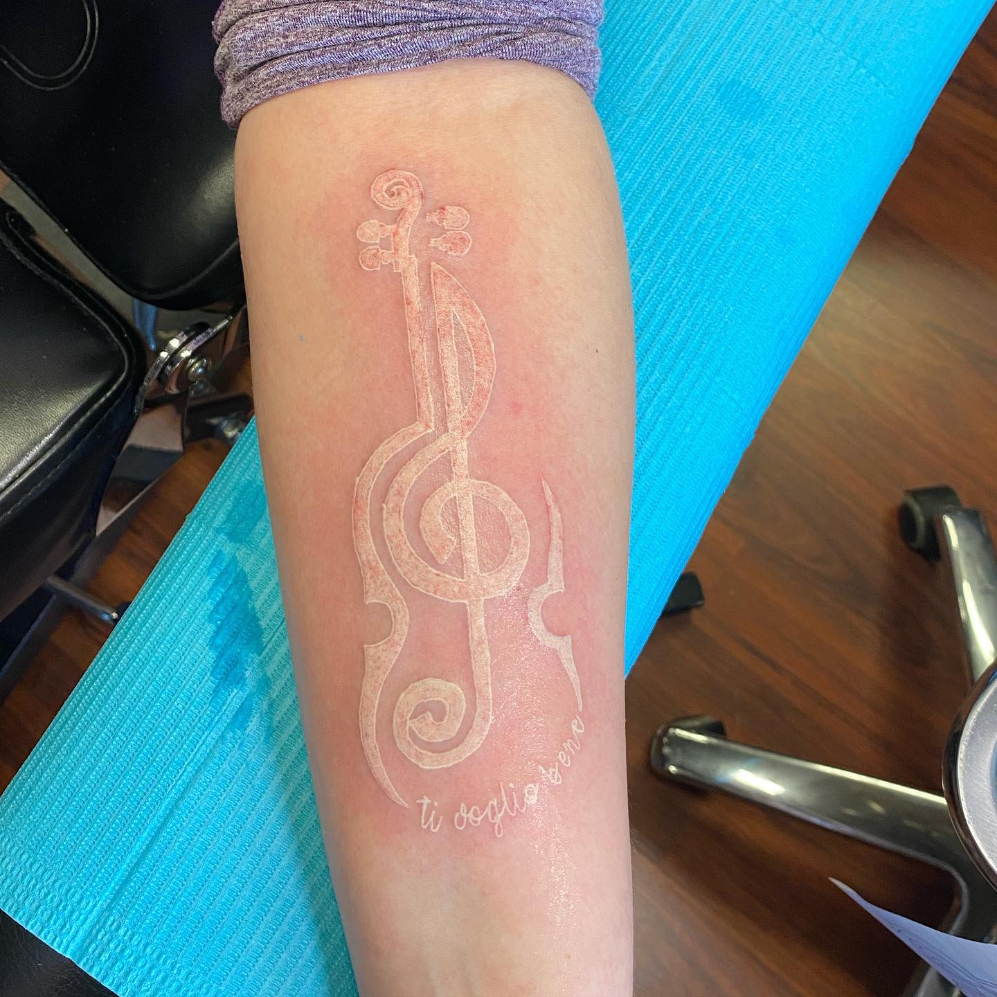 Tatuaje de violín con tinta blanca