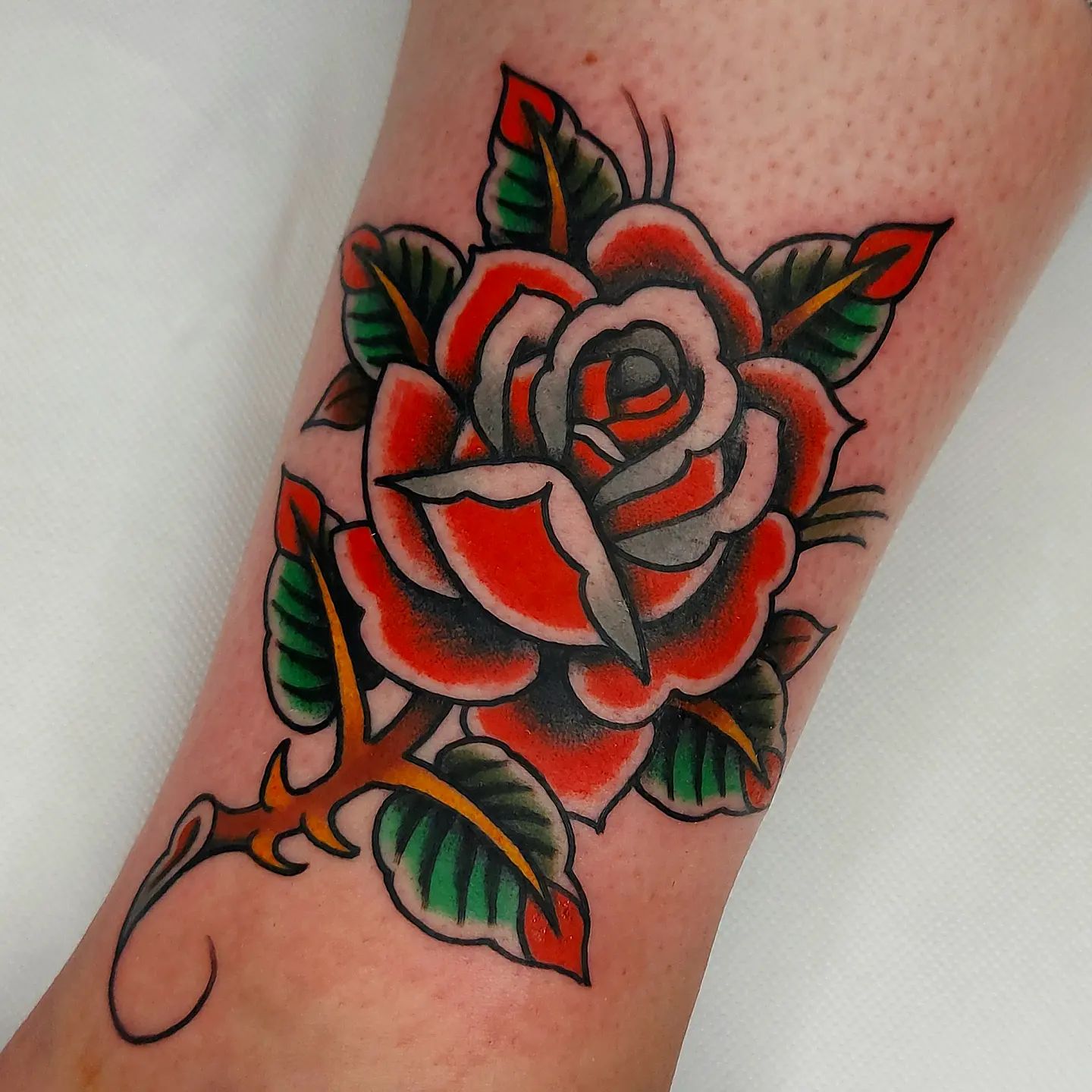 Tatuaje detallado de rosa artística.