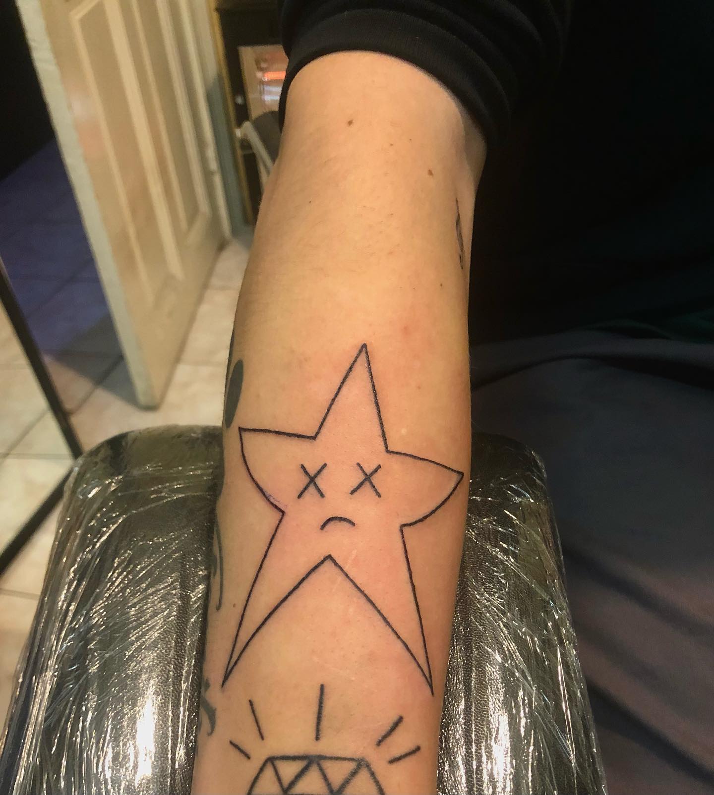 Tatuaje de estrella de línea linda en el brazo