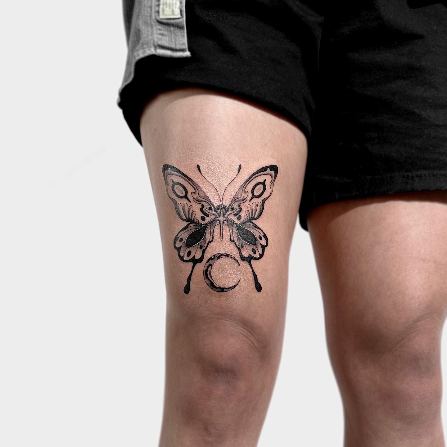 Tatuaje de mariposa negra en la pierna.