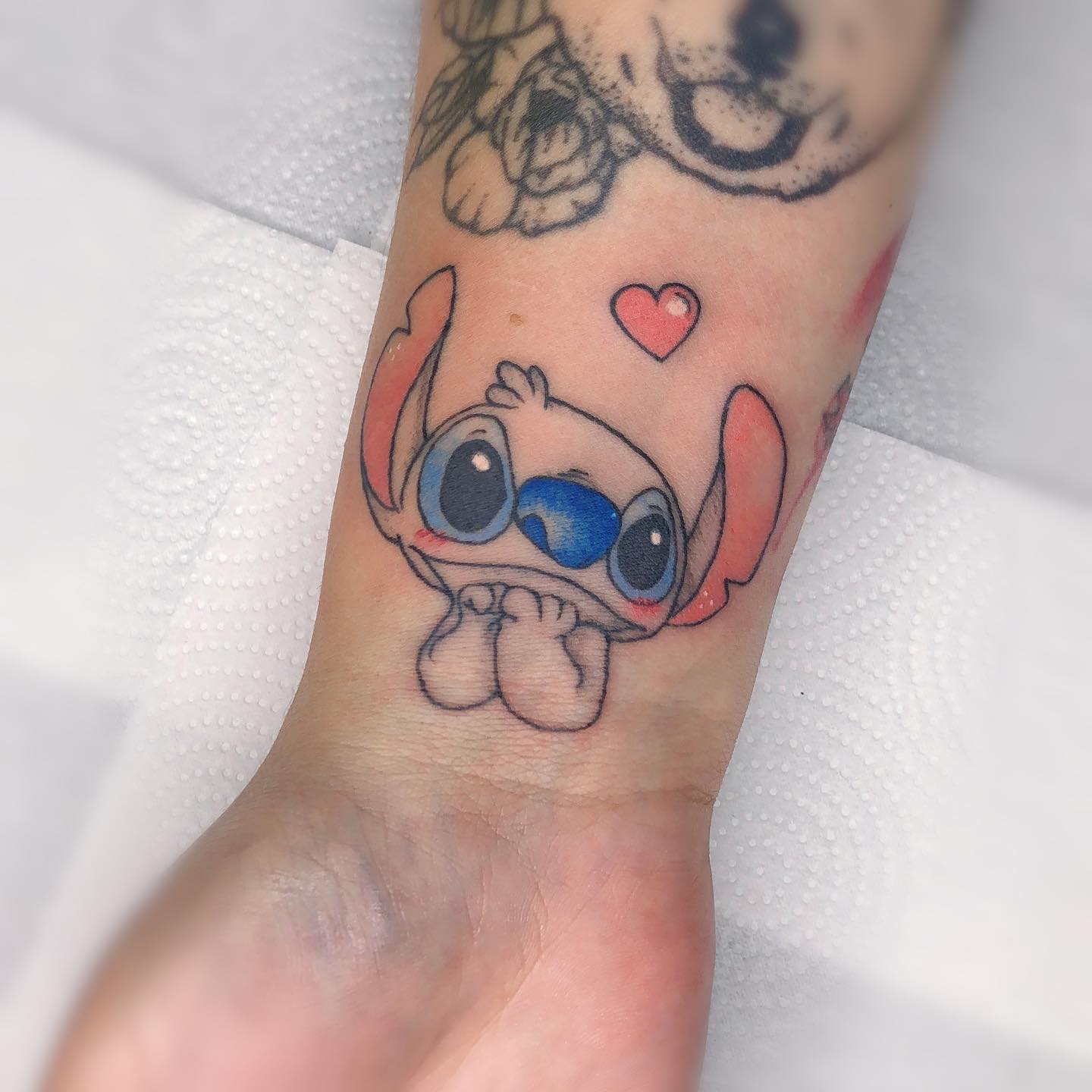 Tatuaje divertido de Stitch en el brazo.