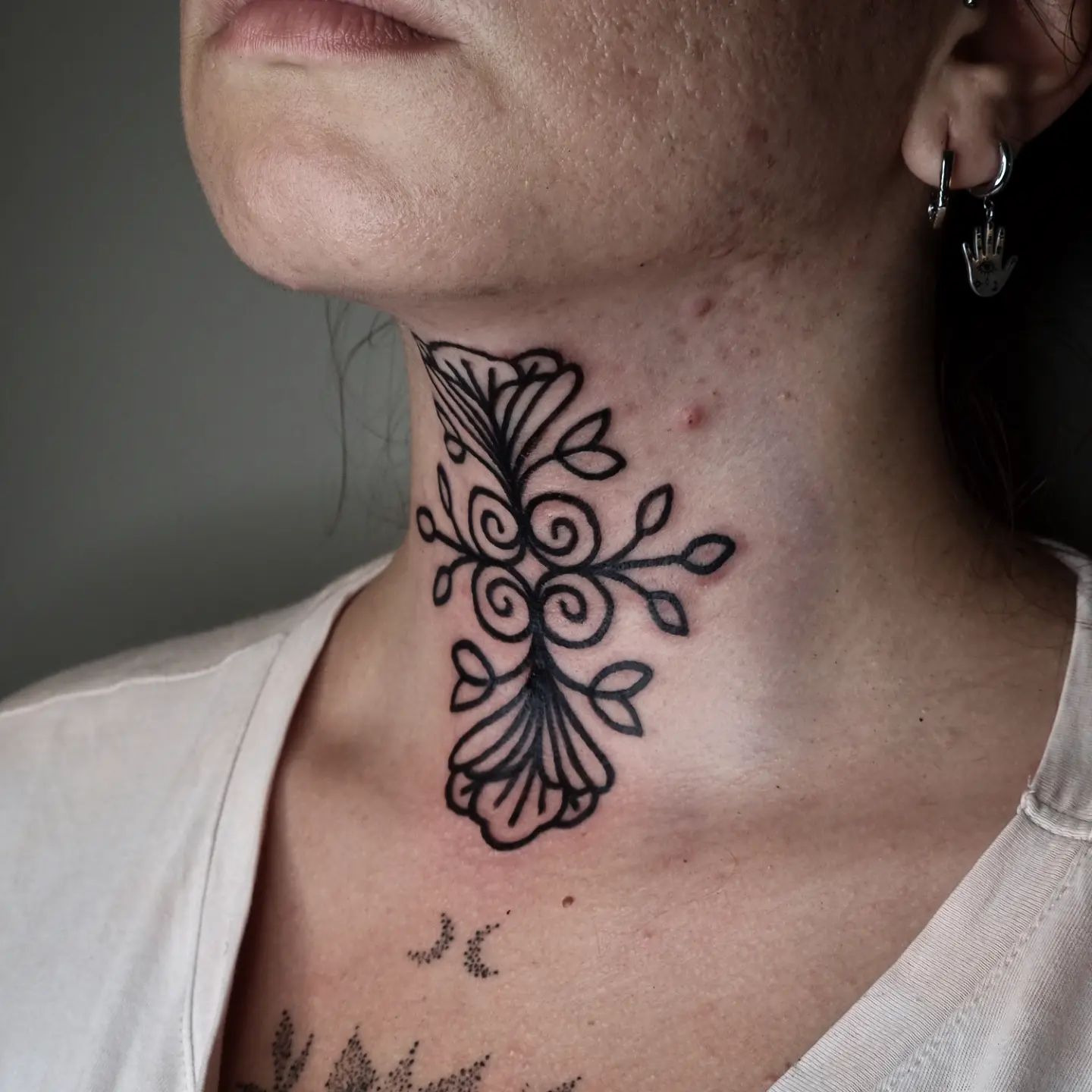 Tatuaje geométrico en la garganta