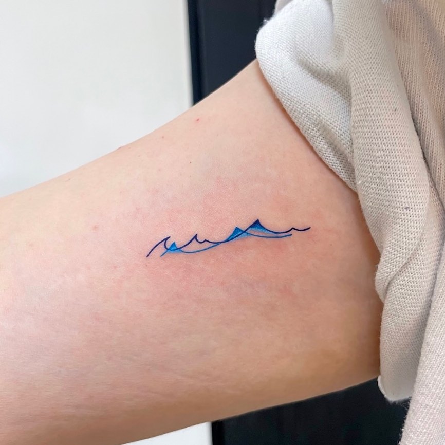 Diseño de tatuaje de pequeña ola azul.