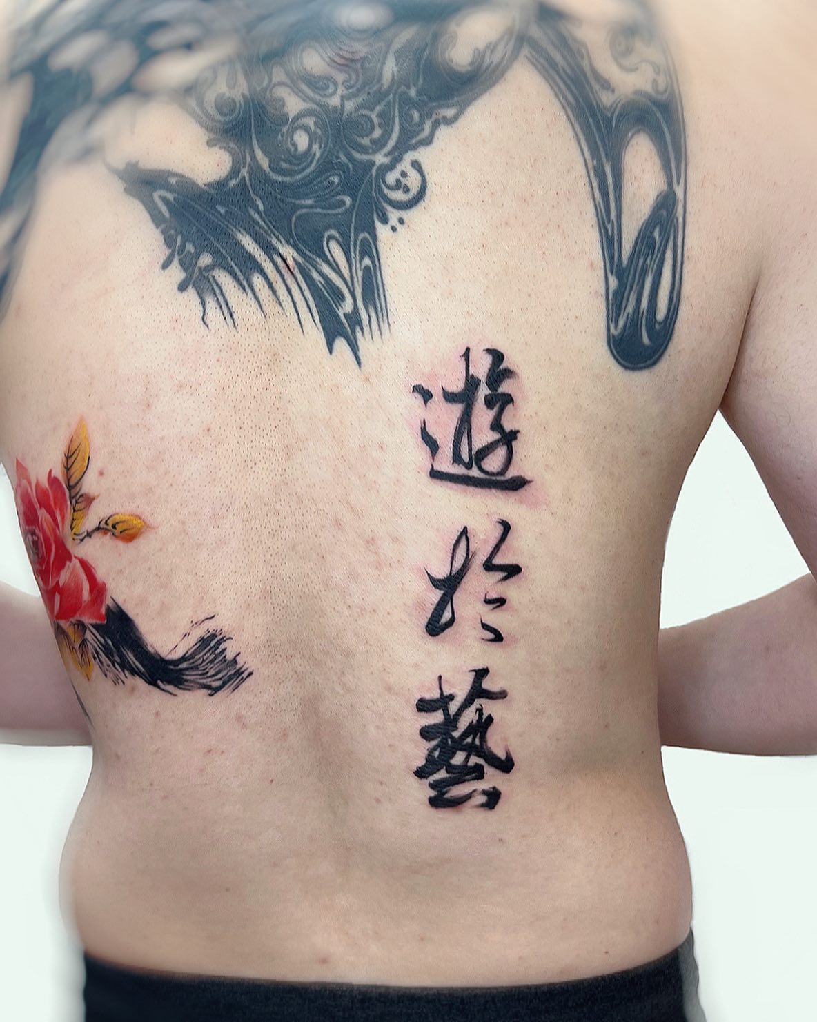 Fabuloso tatuaje de letra china en la espalda.