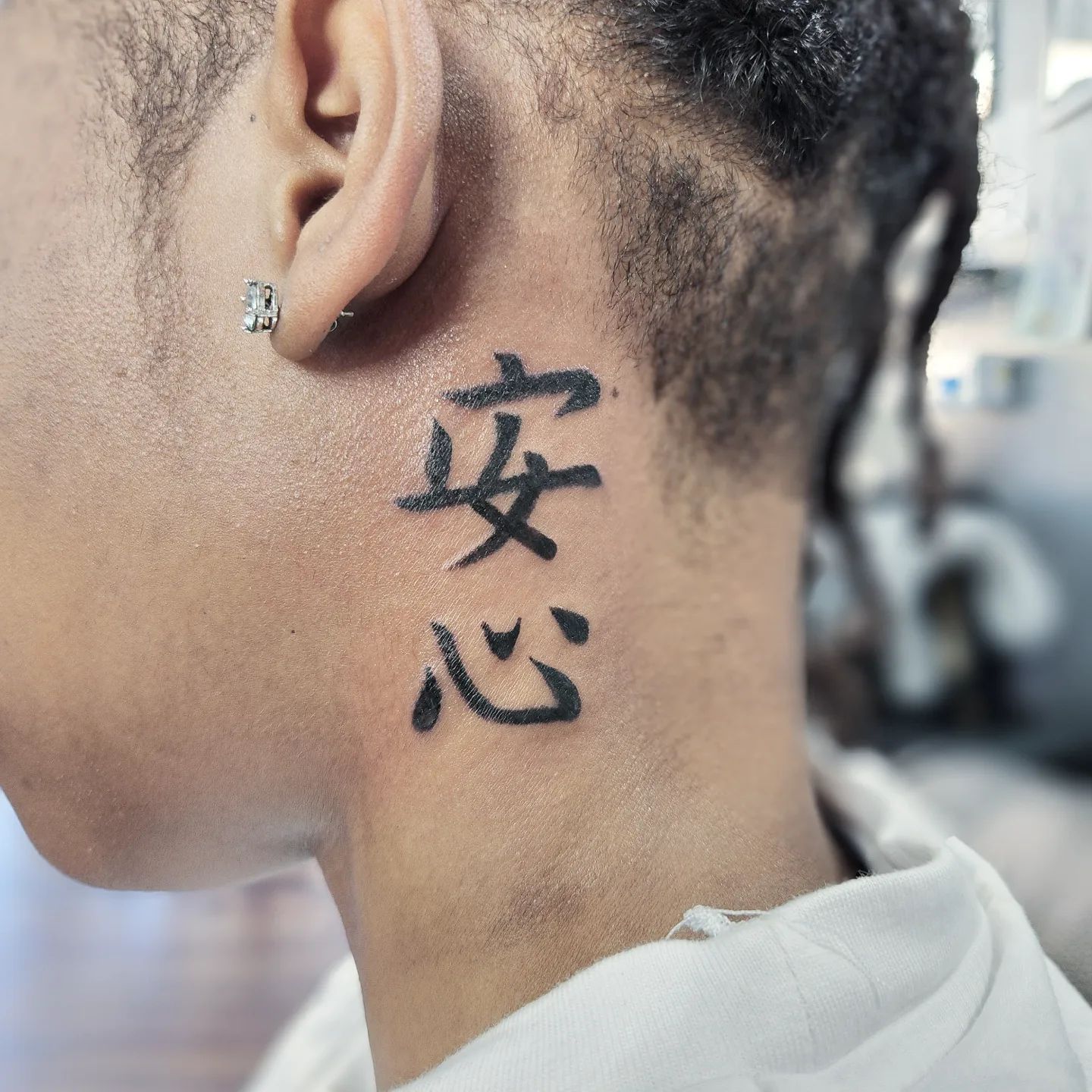 Tatuaje chino detrás de la oreja