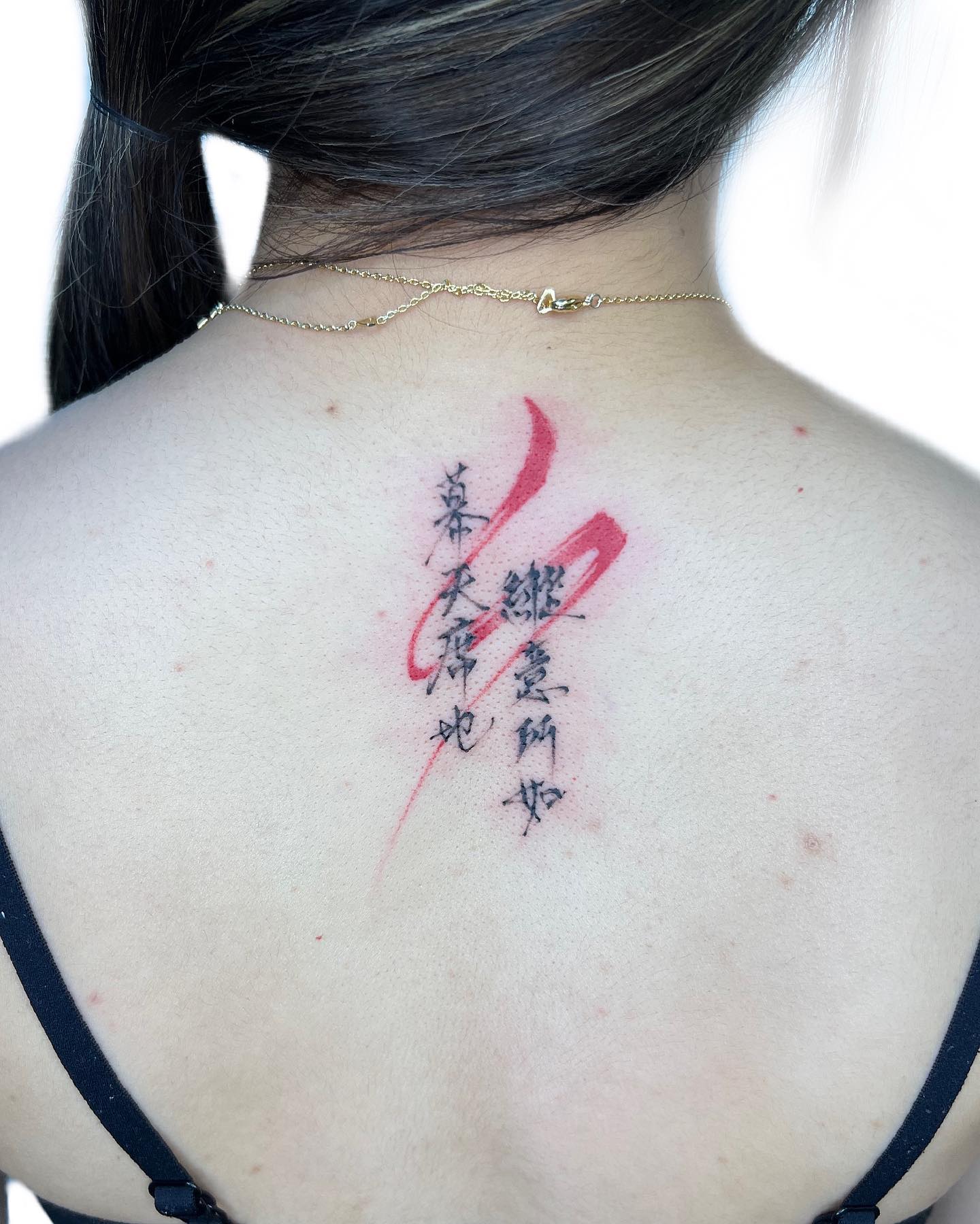 Tatuaje chino en la espalda con salpicaduras.