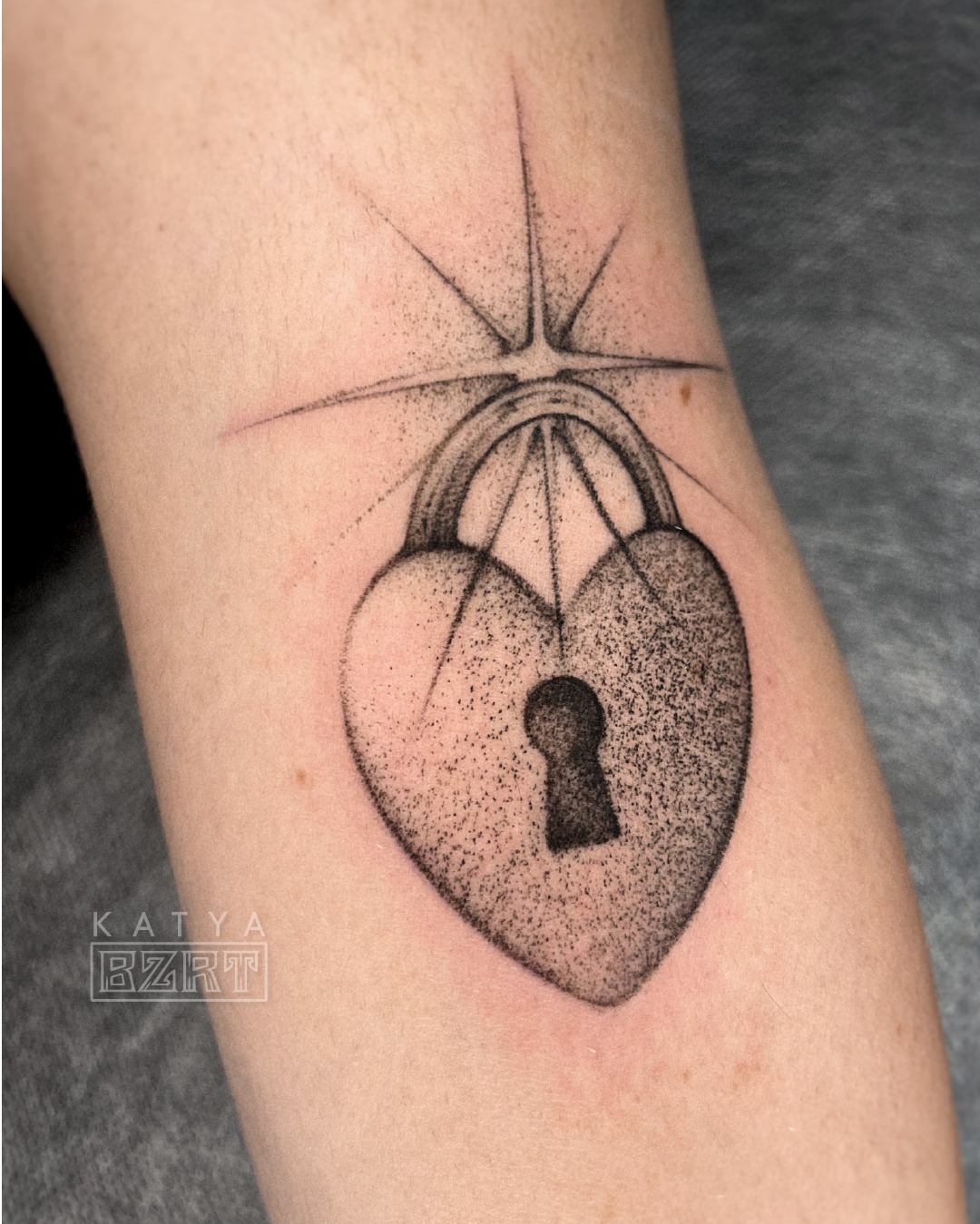 Tatuaje de candado de corazón realizado con puntillismo