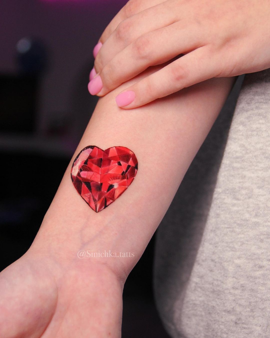 Tatuaje de corazón de cristal rojo.