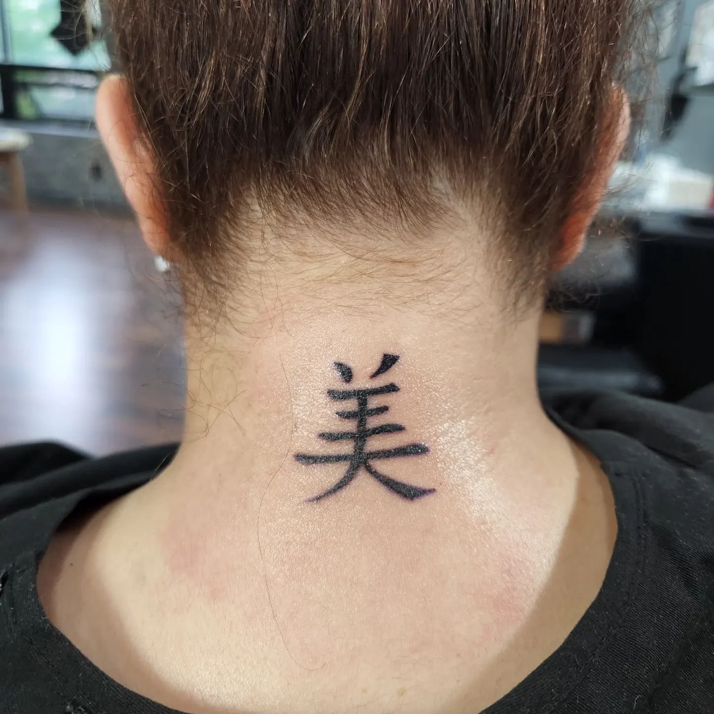 Tatuaje de letra china de belleza en la parte posterior del cuello