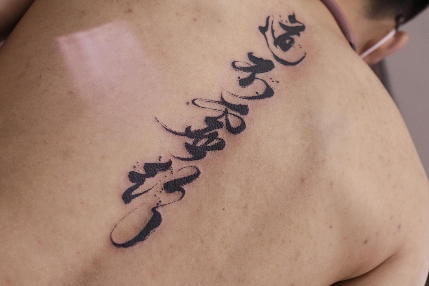 Tatuaje de letra china en la espalda