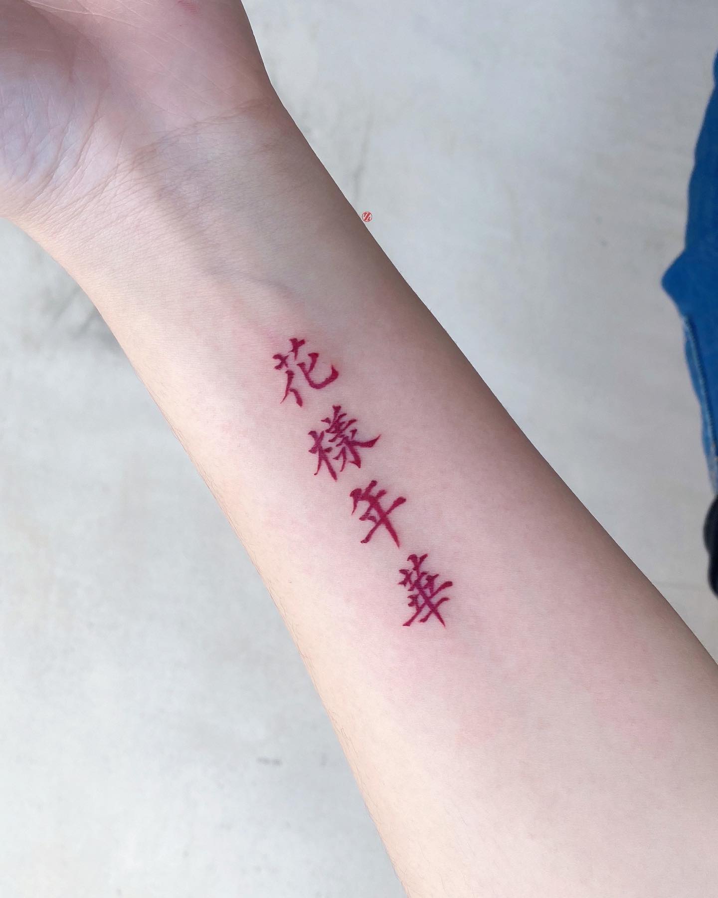 Tatuaje rojo chino en el brazo interior.