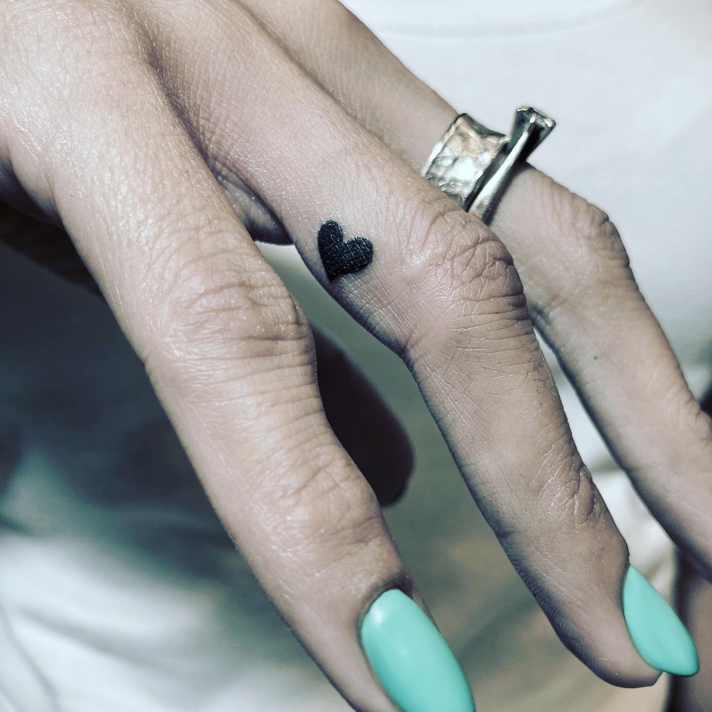 Tatuaje sencillo de corazón en el dedo.